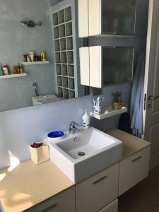 y baño con lavabo blanco y espejo. en Trilocale pregiato sul mare, en San Bartolomeo al Mare