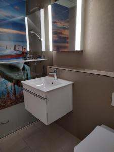 ein Bad mit einem Waschbecken, einem Spiegel und einem Boot in der Unterkunft Klein aber fein in Escholzmatt