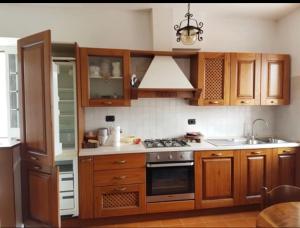 La cuisine est équipée de placards en bois et d'un four avec plaques de cuisson. dans l'établissement Case Apuane, à Minucciano