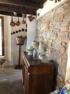 cocina con pared de piedra y armario de madera en Suggestivo casale in collina, en Cassano