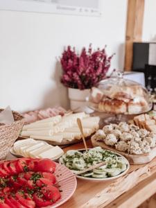 una mesa con queso y otros alimentos en ella en Koralik - BOHO Apartamenty z BALIĄ w CENIE! Kluszkowce - 1 km od Velo Czorsztyn i CzorsztynSKI, en Kluszkowce