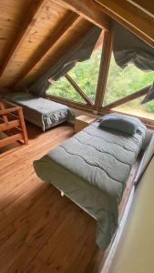 een zolderkamer met een bed en een raam bij Cabaña Lago Nahuel Huapi - Bariloche in Bariloche