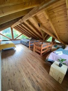 een grote kamer met 2 bedden en een houten plafond bij Cabaña Lago Nahuel Huapi - Bariloche in Bariloche