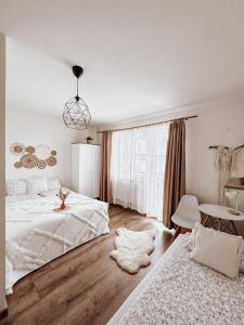 1 dormitorio blanco con 2 camas y mesa en Koralik - BOHO Apartamenty z BALIĄ w CENIE! Kluszkowce - 1 km od Velo Czorsztyn i CzorsztynSKI, en Kluszkowce