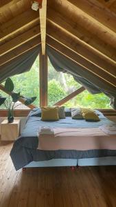 een bed in een kamer met een groot raam bij Cabaña Lago Nahuel Huapi - Bariloche in Bariloche