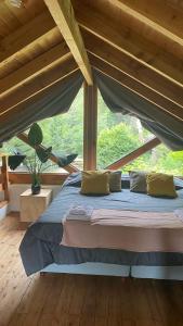 a bed in a room with a large window at Cabaña Lago Nahuel Huapi - Bariloche in San Carlos de Bariloche