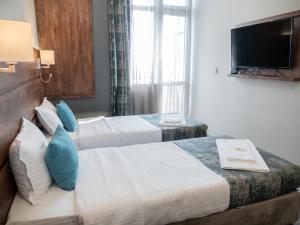 a hotel room with two beds and a television at Mountain Sky View - Маунтин Скай Вю in Gabrovo +32 photos