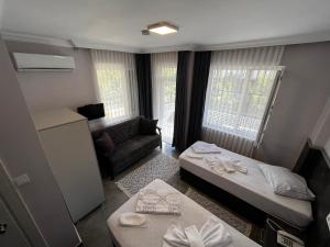 um pequeno quarto com uma cama e um sofá em Lara Hakan Family Apart em Antalya