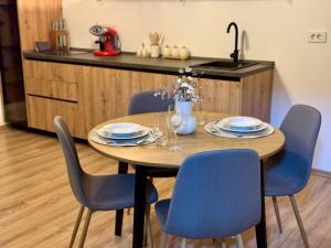 drewniany stół z niebieskimi krzesłami i kuchnia w obiekcie DD Apartments - Mavrovo w mieście Mavrovo