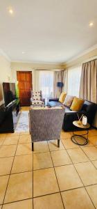 a living room with a couch and a tv at A Warm 3 bed Townhouse in a secure complex in Witbank
