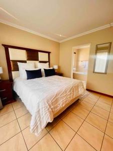 a bedroom with a large bed with blue pillows at A Warm 3 bed Townhouse in a secure complex in Witbank