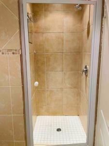 a shower with a glass door in a bathroom at A Warm 3 bed Townhouse in a secure complex in Witbank
