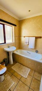 ein Badezimmer mit einer Badewanne, einem Waschbecken und einem WC in der Unterkunft A Warm 3 bed Townhouse in a secure complex in Witbank