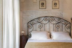 een bed met een metalen hoofdeinde en 2 kussens bij Abbazia San Pietro In Valle in Ferentillo