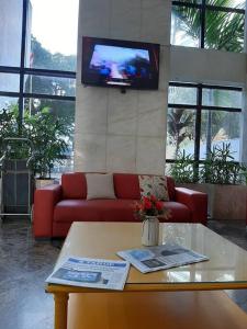 sala de estar con sofá rojo y TV en Flat no Sol Vitória Marina 2, en Salvador