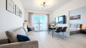 ein Wohnzimmer mit einem Sofa und einem Tisch in der Unterkunft Apartamenty Sun & Snow Pelikan in Rewal