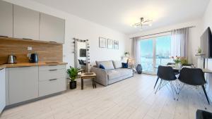 eine Küche und ein Wohnzimmer mit einem Sofa und einem Tisch in der Unterkunft Apartamenty Sun & Snow Pelikan in Rewal