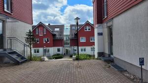 a row of red and white buildings in a courtyard at Wohlfühl-Ferienwohnung mit Tiefgarage im Grünen in Oberhof