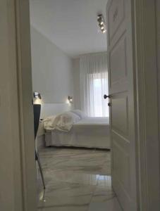 Castellammare di VeliaにあるApartment Marina di Ascea 1の白いベッドルーム(ベッド1台、窓付)