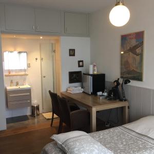 a bedroom with a desk and a bed and a room at Cessinas in Groningen