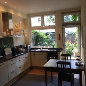 a kitchen with a table and two windows in it at Cessinas in Groningen