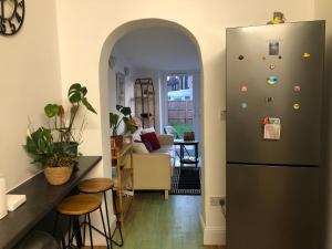 a kitchen with a refrigerator and a living room at Butterfly Home in London