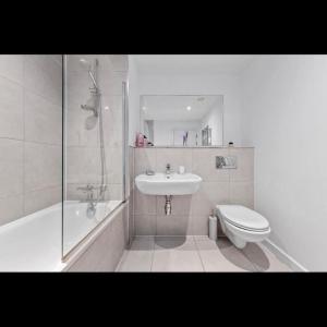 a bathroom with a sink and a toilet and a shower at Delta 1 Br Apartment in London DP328 in Croydon