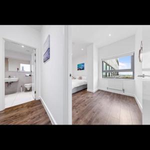 a large white bathroom with a sink and a mirror at Delta 1 Br Apartment in London DP328 in Croydon
