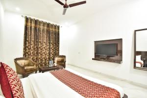 una camera da letto con un letto e una TV a schermo piatto di Hotel Royal Place a Tarn Tāran