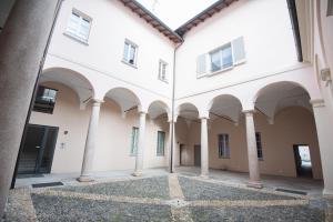an empty courtyard of a building with columns at Dimora Palazzo delle Gabette - Centro Storico in Pavia