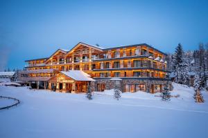 a large lodge in the snow with snow covered trees at Alpin Peaks in Turracher Hohe