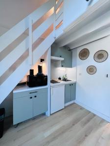 une cuisine avec des placards blancs et un escalier dans l'établissement La dunette, à Le Touquet-Paris-Plage 3 autres photos