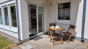 a wooden table and two chairs on a patio at Wohlfühl-Ferienwohnung mit Tiefgarage im Grünen in Oberhof
