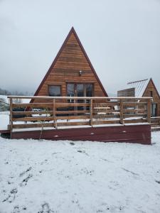 uma cabana de madeira na neve com uma cerca em Chalet en A de la Motte-Fanjas 