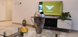 a living room with a tv and a vase on a table at SVIZONA Premium 2BHK, Burj Khalifa View, Downtown Dubai in Dubai