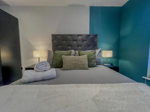 a bedroom with a large bed with a blue wall at Orange Rentals-City Centre - High Spec - The Aqua Suite, Sleeps 4 in Liverpool