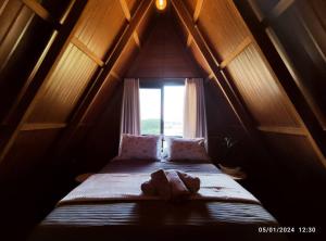 Cama pequeña en habitación con ventana en Cabana com hidro e natureza!, en Estefânia