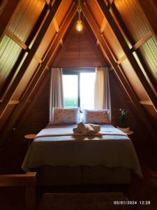 Cama en habitación con ventana en Cabana com hidro e natureza!, en Estefânia