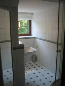 a bathroom with a tub and a sink and a window at FeWoFahrdorf in Fahrdorf