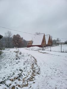 ein schneebedecktes Feld mit einer Scheune und einem Zaun in der Unterkunft Chalet en A de la Motte-Fanjas 