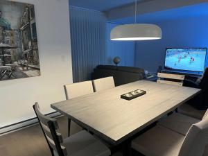 a dining room with a table and a television at Nouveau Condo Québec in Quebec City