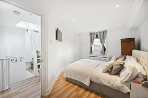 a white bedroom with a bed and a mirror at Close to Kensington palace located double room in London