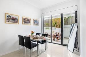 a dining room with a table and black chairs at Central of Toowong Neat Apt Near Station in Brisbane