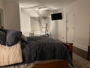 1 dormitorio con 1 cama y TV en la pared en The Brower House en Saint Cloud