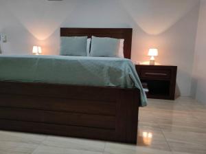 a bedroom with a bed and two lamps on a night stand at Mandy Loft -40MB wifi -estacionamiento gratuito in San Ramón