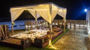 einen Esstisch unter einem Zelt am Strand in der Nacht in der Unterkunft Complexe Hôtelier Sabah in Nouakchott