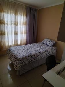 a small bedroom with a bed and a window at The Grace quest house in Ngodini