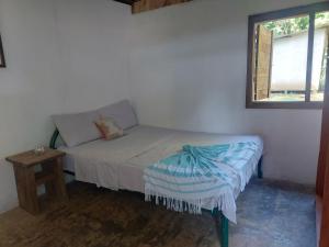 a small bedroom with a bed and a window at Anez Cabin'S in Cabuya