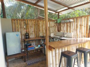 una cocina en una cabaña de madera con taburetes y barra en Anez Cabin'S, en Cabuya