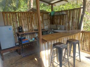 an outdoor kitchen with two stools and a counter at Anez Cabin'S in Cabuya +37 photos
